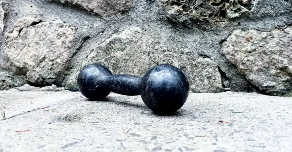Black dumbbell on stone surface representing strength training for men over 40
